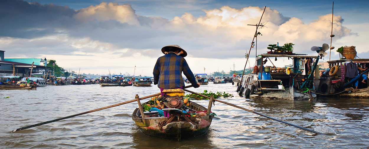 A stock photo of a boatman sailing into a fishing village.