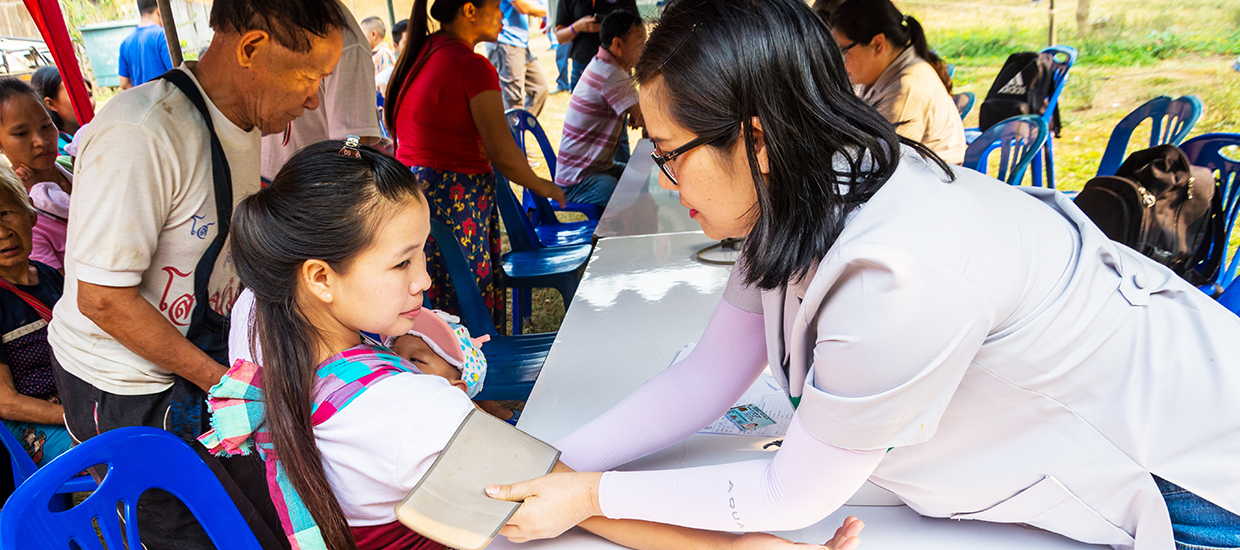 A healthcare worker is checking the blood pressure of a little girl. 