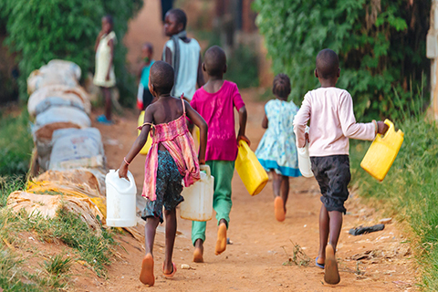 A stock photo of a group of children collecting water.