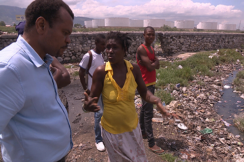 This photo was taken in Haiti. Dr. Marcelin is photographed having a conversation with several community members.